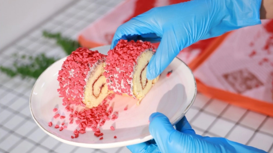 La mano enguantada toma un pedazo de pastel